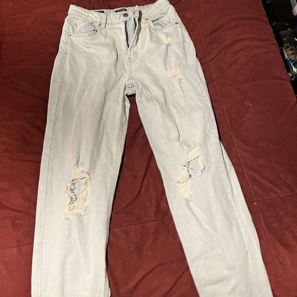 Light blue jeans, ripped at knees, wide leg